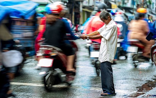 Xúc động trước hình ảnh cụ ông bán vé số mếu máo giữa dòng người tấp nập 'chạy mưa' ở Sài Gòn