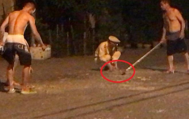 Chiến sĩ CSGT cùng người dân thu dọn vật liệu rơi vãi trên quốc lộ trong đêm