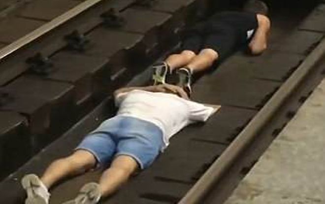 Hai thanh niên liều mình nhảy xuống đường ray chờ tàu đi qua