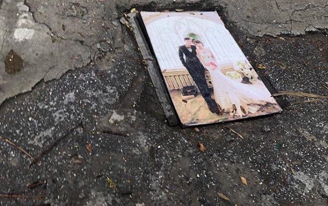 Trời mưa bão, cặp vợ chồng mang ảnh cưới ra làm… nắp cống