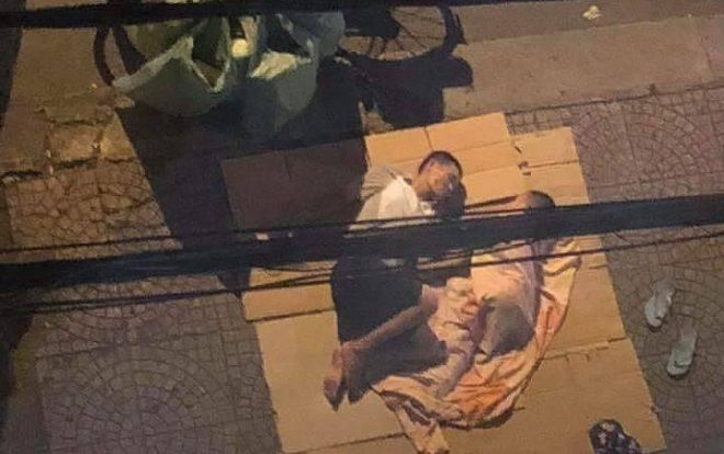 Bức ảnh hai cha con nằm ngủ trên tấm bìa các tông ở vỉa hè, bên cạnh chiếc xe đạp chở phế liệu khiến bao người xúc động