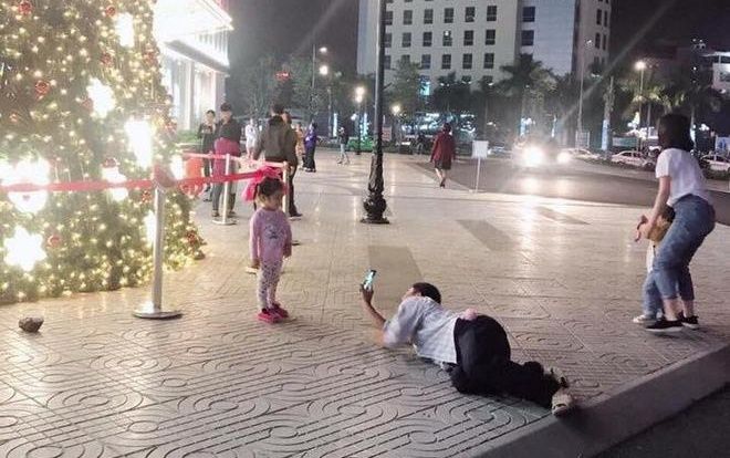 Ấm áp cảnh người bố chân đi dép tổ ong nằm rạp xuống đất chụp ảnh cho con gái nhỏ