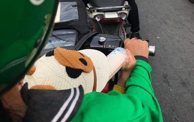 Chuyện nữ tài xế GrabBike vừa chở khách vừa cho con bú bình khiến dân mạng cảm động vì gánh nặng mưu sinh