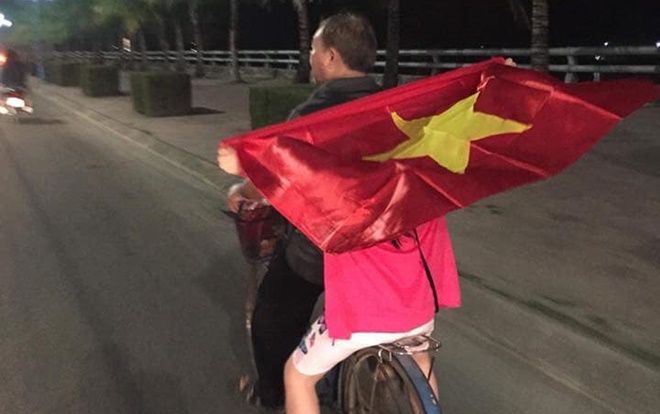 Bức ảnh 2 ông cháu nhẹ nhàng 'đi bão' trên chiếc xe đạp phủ rực màu cờ sắc áo khiến nhiều người xuýt xoa