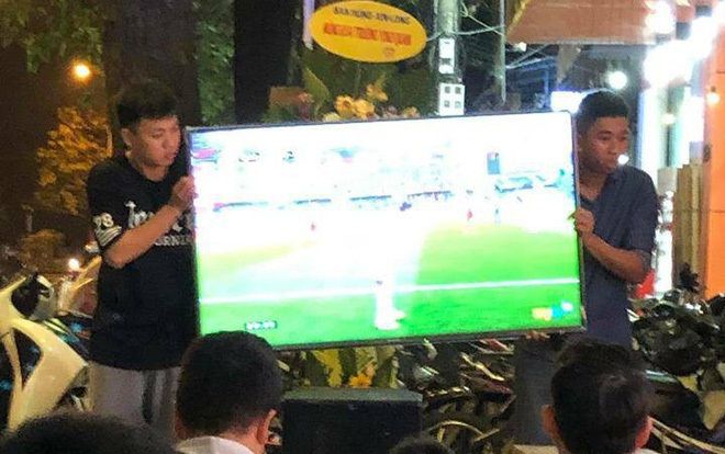 Hỏi có ai 'số khổ' như hai thanh niên phải đứng bê tivi suốt trận bóng cho khách hàng xem