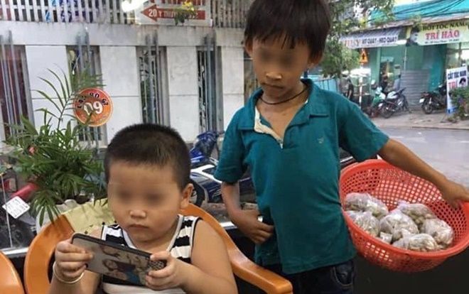 Bức ảnh cậu bé bán hàng rong lặng lẽ 'xem ké' điện thoại của người bạn cùng tuổi khiến nhiều người phải suy ngẫm