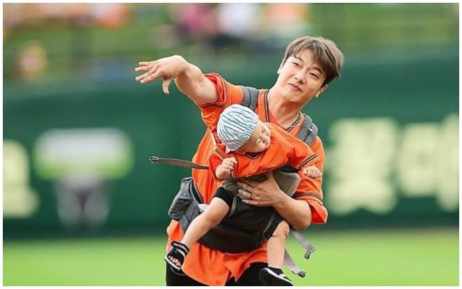 Đôi vợ chồng idol trẻ Minhwan (FT.ISLAND) và Yulhee nhận rổ gạch đá vì vừa địu con trai 2 tuổi vừa ném bóng chày