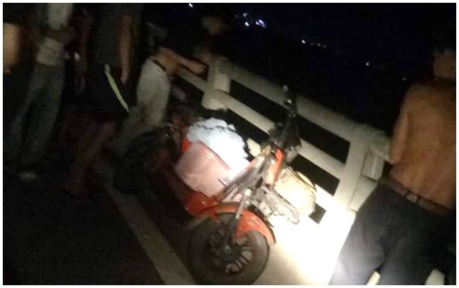 Người phụ nữ mang giỏ quần áo, đi xe đạp điện lên cầu tự tử