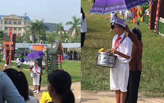 Bức ảnh người bà lom khom che ô cho cháu tập nghi thức đội giữa trưa nắng