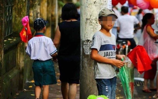 Bức ảnh đối lập gây xúc động mạnh: Cậu bé bán cờ bên vệ đường và cậu bé mặc đồng phục mới trong ngày khai giảng