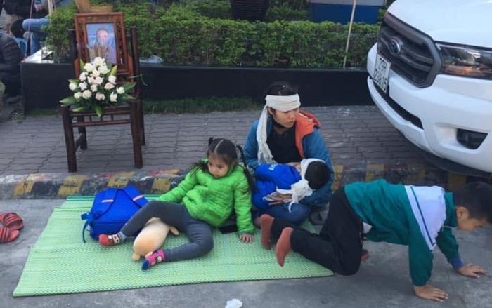 Người phụ nữ mang di ảnh chồng, ôm 3 con nhỏ ngồi trước cửa ‘bắt đền’ Công ty Ford Thanh Xuân