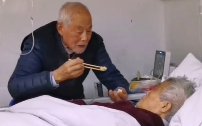 Cảm động cụ ông xúc từng thìa cơm cho vợ trên giường bệnh dù cả hai cùng nhiễm virus corona