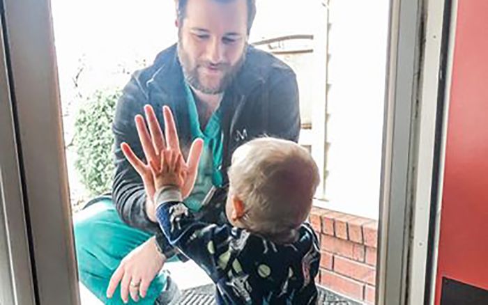 Xúc động khoảnh khắc bác sĩ chỉ dám chạm tay con trai qua lớp cửa kính vì COVID-19