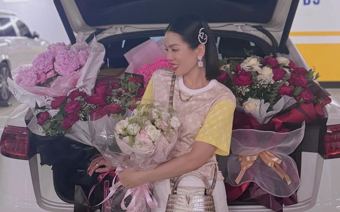 Lệ Quyên cười rạng rỡ giữa cốp xe ngập tràn sắc hoa, đón nhận quà từ người đặc biệt