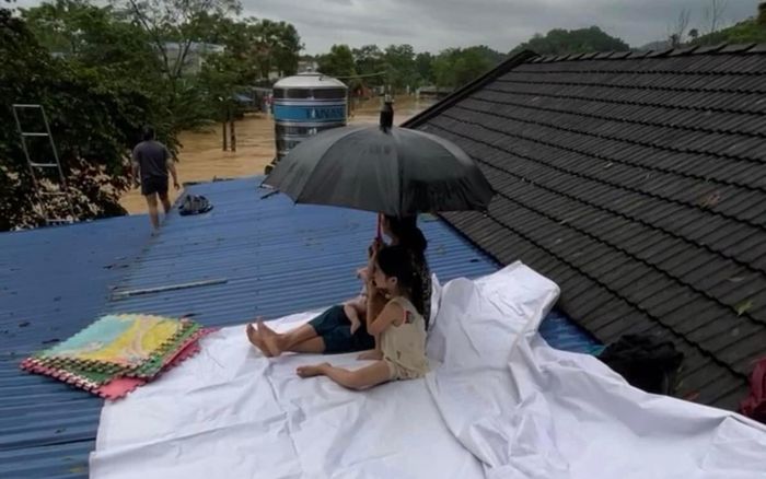 Xót lòng cảnh người mẹ cố che chắn cho 2 con nhỏ khi nước lũ đã dâng đến nóc nhà