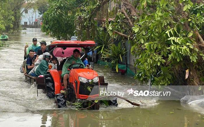 Người dân Chương Mỹ vội vã chạy khỏi lũ sâu ngang ngực bằng thuyền, xe máy kéo