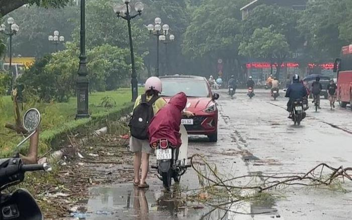 Cô gái dắt xe máy vì chở theo em nhỏ lúc trời mưa, dân tình lại gần thì được phen ngã ngửa