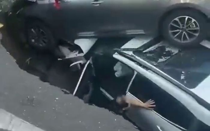 Hố sụt 'nuốt chửng' hai ô tô trên đường phố, ba người bị thương