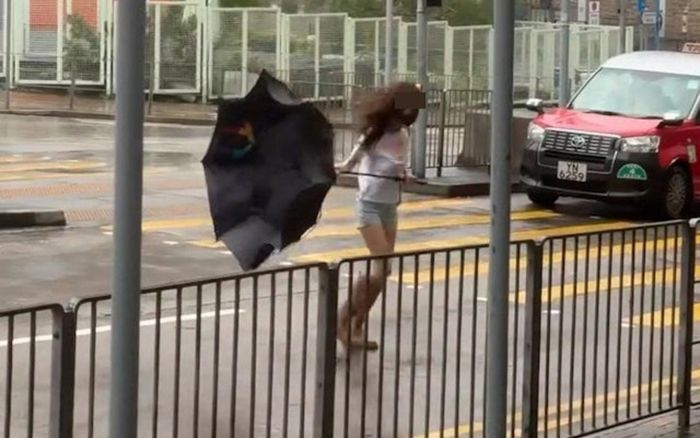 Clip: Cô gái vật lộn với bão Wipha, bị gió xé toạc chiếc ô tan tành