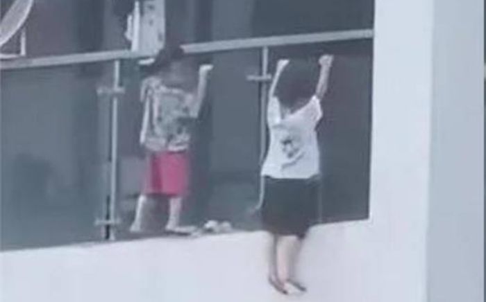 Xôn xao hai đứa trẻ leo ra ngoài ban công tầng 13 chơi đùa như 'hít xà'