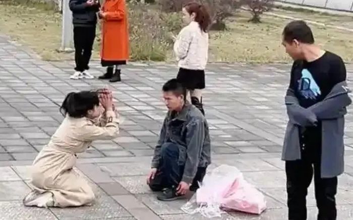 Cô gái quỳ gối giữa đường, liên tục cúi đầu cầu xin một người đàn ông vì một lý do