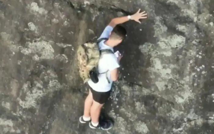 Mắc kẹt trên vách đá cao 80m không dây bảo hộ, người đàn ông có hành động gây tranh cãi