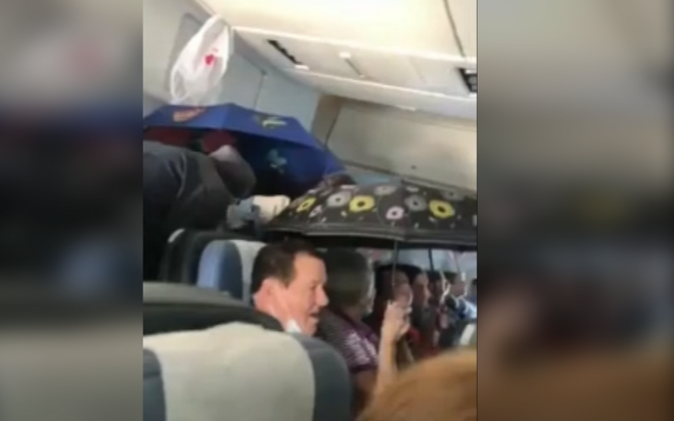 Hành khách dùng ô 'che mưa' trong máy bay