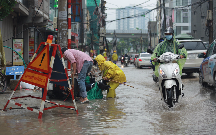 Mưa lớn khiến nhiều tuyến đường Hà Nội chìm trong 'biển nước', người đi xe máy ngã lăn ra đường
