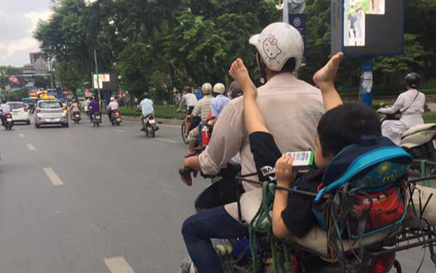 Khoảnh khắc cậu bé nằm vắt chân lên lưng người bố trên đường đến trường gây tranh cãi