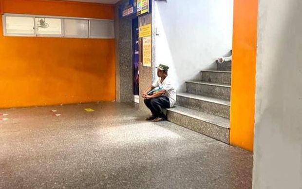 Ông bố lặng lẽ ngồi nơi góc cầu thang sau khi nhập học cho con, ánh mắt với bao điều lo toan khiến bao người rưng rưng