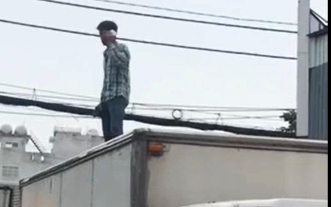 Nam thanh niên nghi 'ngáo đá', tay cầm dao bất ngờ leo lên nóc xe tải đứng nói nhảm