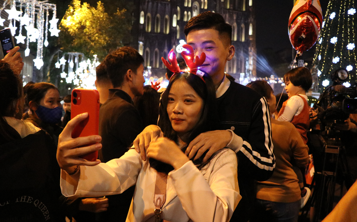 Cặp đôi chen chân tạo dáng, tự sướng chụp ảnh trong đêm Noel