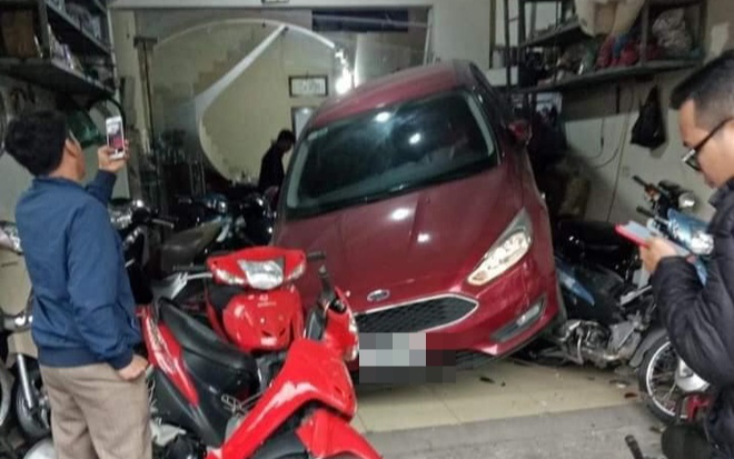 Pha lùi xe bất cẩn khiến cả chiếc ô tô nằm gọn trong hàng sửa xe bên đường