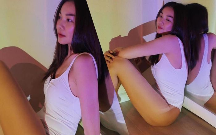 Chị đẹp Thanh Hằng mặc bodysuit trắng thả dáng gợi cảm dưới ánh đèn mơ màng