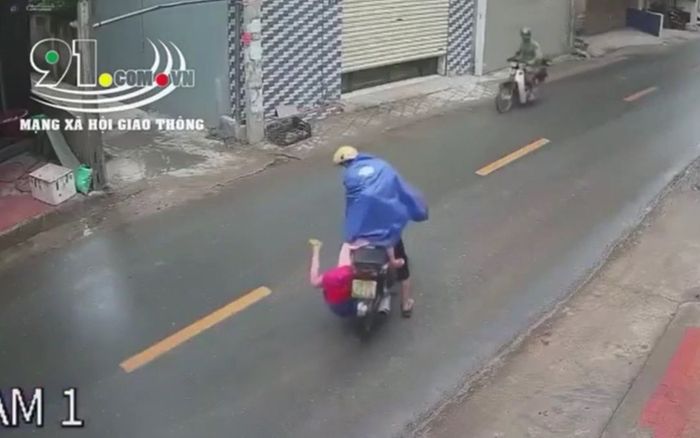 'Đứng tim' trước cảnh con nhỏ ngồi sau xe bất ngờ ngã nhào xuống đường chỉ vì chiếc áo mưa