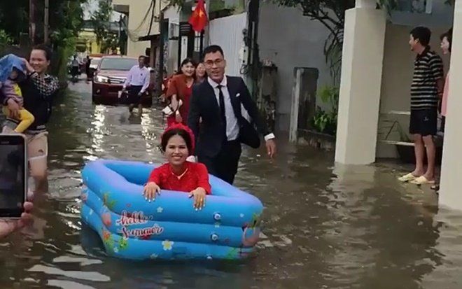 Màn rước dâu đặc biệt gây 'bão' MXH: Cô dâu cười rạng rỡ trong bể bơi phao vượt qua đoạn đường ngập lũ
