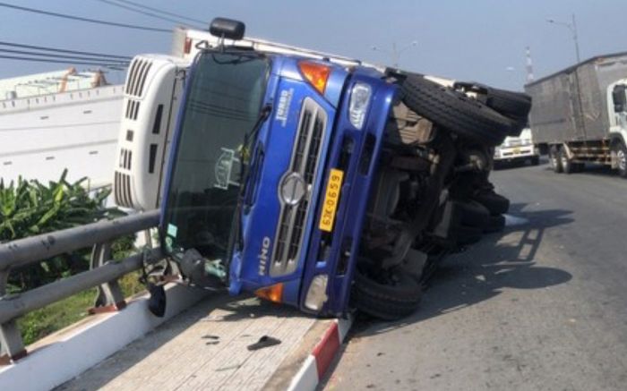 Thót tim cảnh xe tải chở cá lật ngang, đè trên lan can cầu