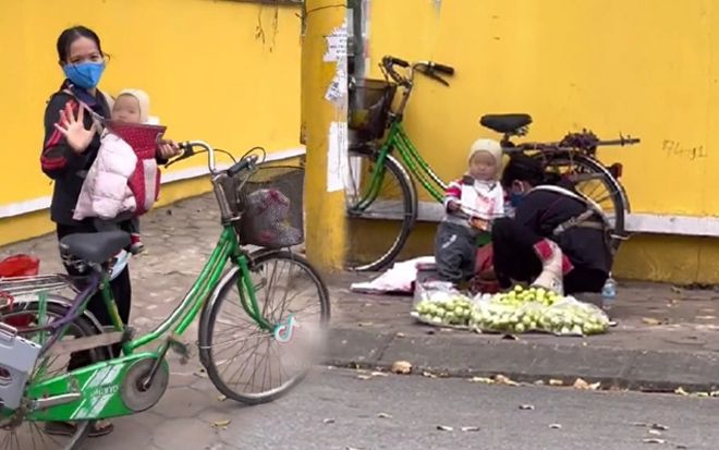 Nghẹn lòng hình ảnh em bé nhỏ rong ruổi theo mẹ đi bán táo mưu sinh