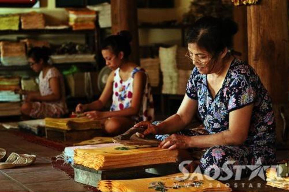 Cô Dung đang ngồi in ván màu cho tranh. Đây được xem là công đoạn cuối cùng của quy trình làm tranh.