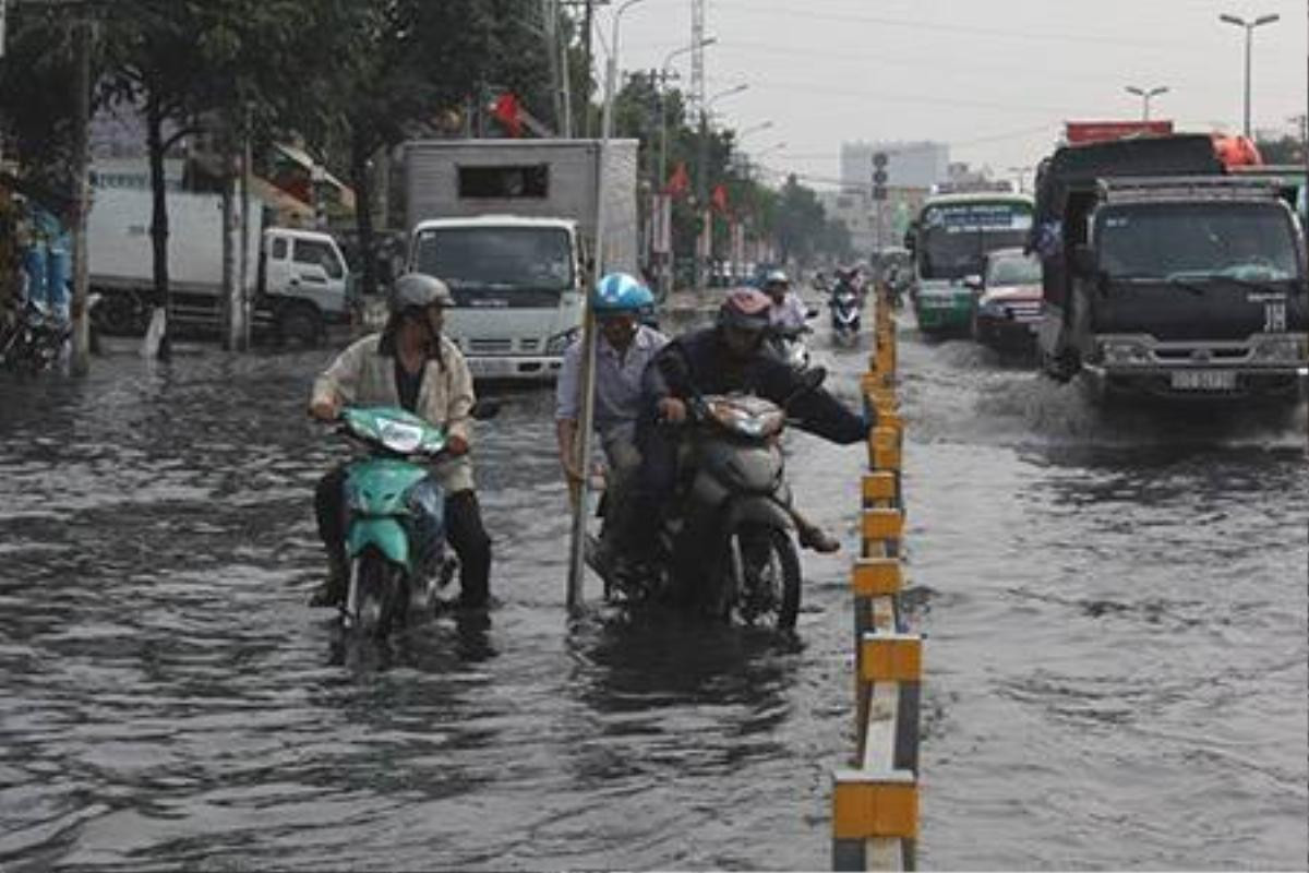 Đoạn ngập kéo dài khoảng 200 m trên đường Kinh Dương Vương (phường An Lạc, quận BÌnh Tân) gây khó khăn cho người đi đường - Ảnh: Phạm Hữu.