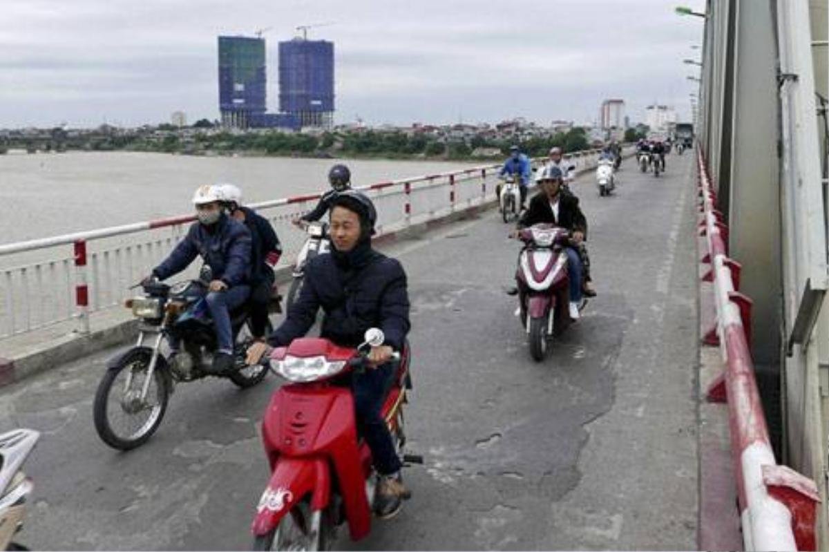 Lạnh nhất là lúc đi qua sông. Trên cầu Chương Dương, gió thổi mạnh khiến người đi đường co ro.