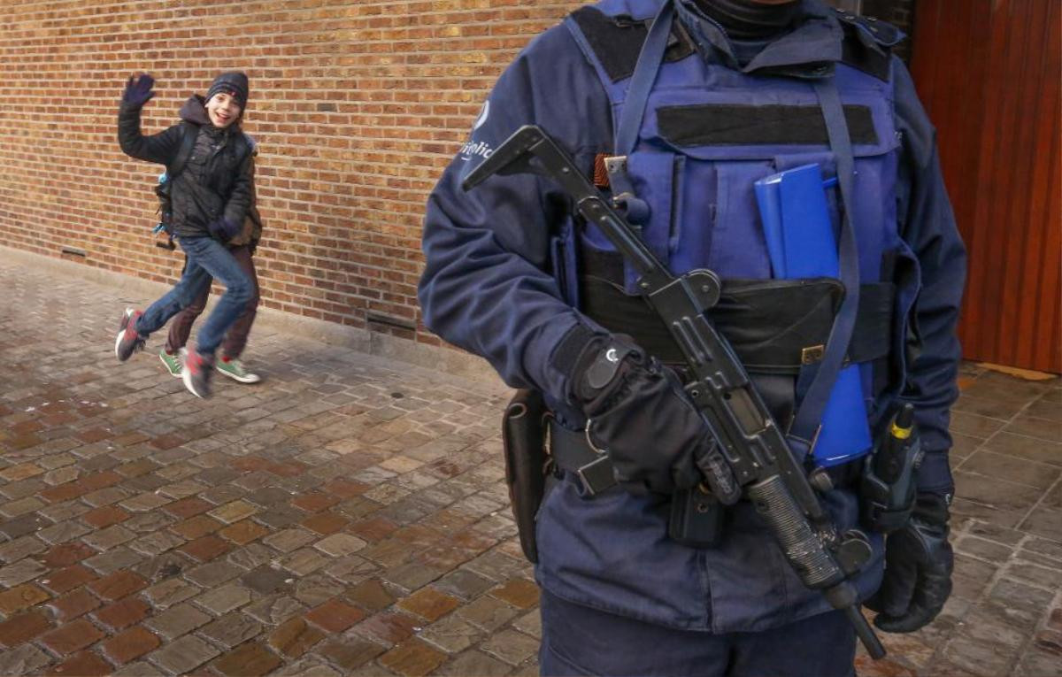 A Belgian police officer stands guard outside a school in central Brussels November 25, 2015. Brussels' schools re-opened on Wednesday after staying closed for two days following tight security measures linked to the fatal attacks in Paris. REUTERS/Yves Herman