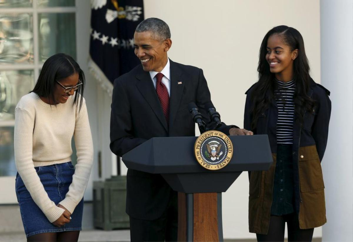 United States President Barack Obama, along with daughters Sasha (L) and Malia (R), attends the 68th annual pardoning of Thanksgiving turkey Abe (not pictured in the Rose Garden of the White House in Washington November 25, 2015. REUTERS/Gary Cameron