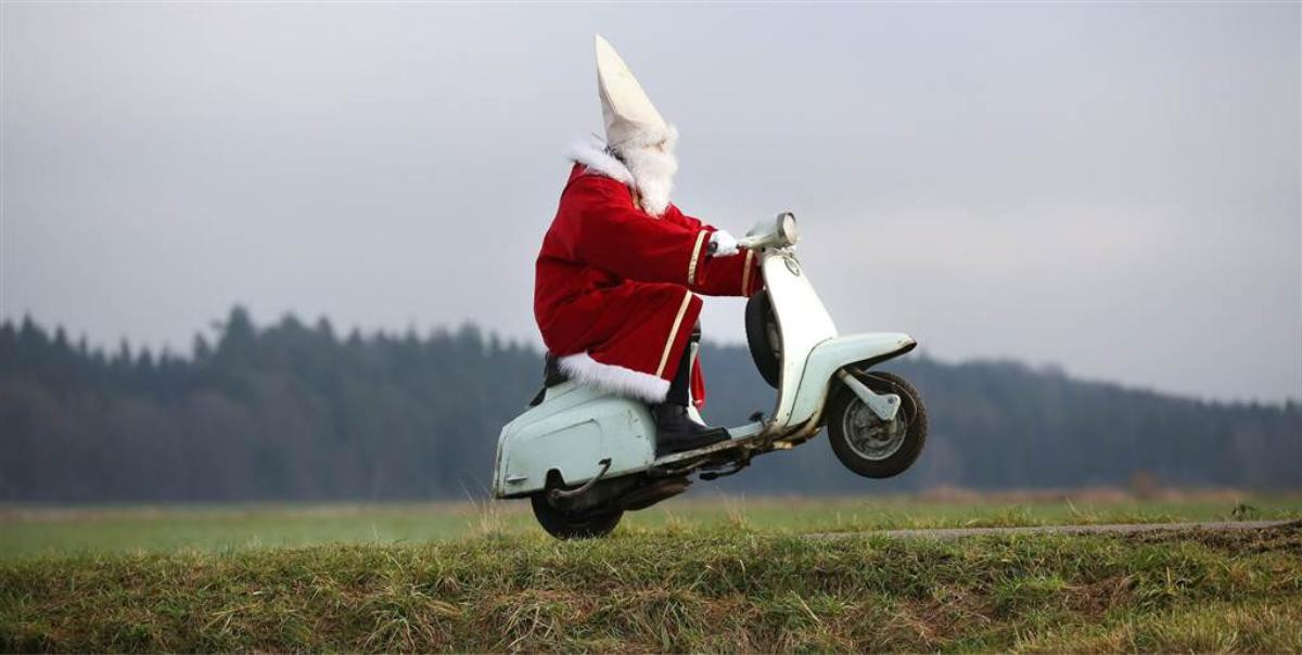 Một chàng trai trong trang phục Ông già Noel phóng vespa về nhà sau tiệc Giáng sinh gần Laubbach, Germany.