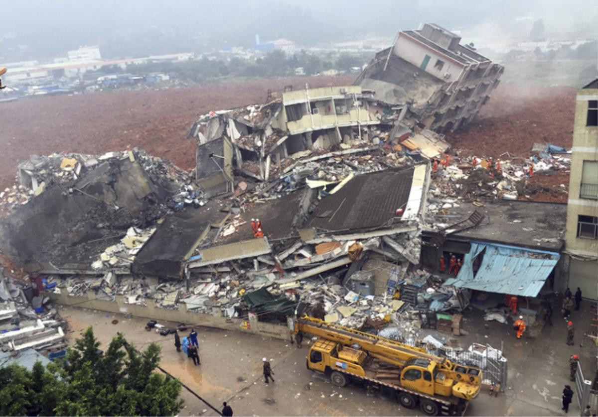 Rescuers search for survivors amongst collapsed buildings after a landslide in Shenzhen, in south China's Guangdong province, Sunday Dec. 20, 2015. The landslide collapsed and buried buildings at and around an industrial park in the southern Chinese city of Shenzhen on Sunday authorities reported. (Chinatopix via AP) CHINA OUT