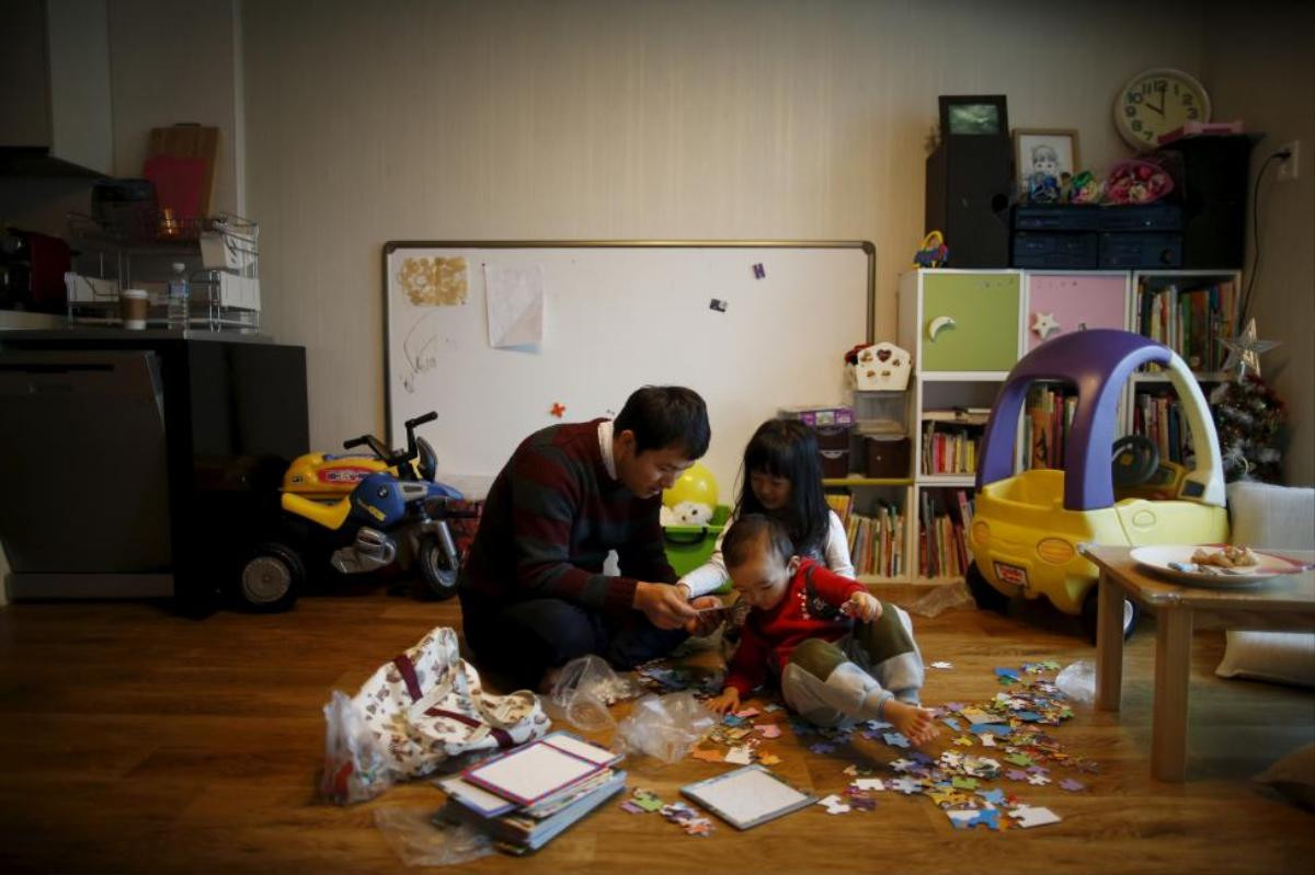 Chung Sang-hoon talks to his daughter and son at their apartment in Seoul, South Korea, December 14, 2015. Fathers who take paternity leave were once so rare in male-dominated South Korea that they are called "superdads". But their ranks are growing. REUTERS/Kim Hong-Ji