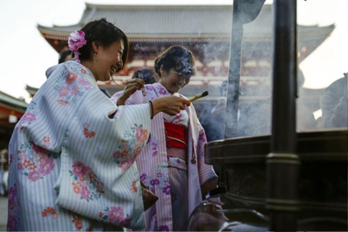 Các cô gái Nhật Bản mặc kimono, đốt hương tại đền Sensoji, Tokyo, trước thềm năm mới.