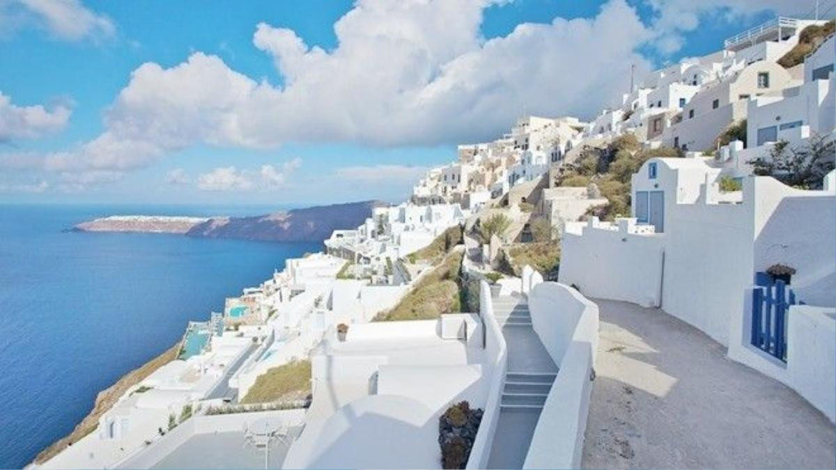 Đảo Santorini được xem là viên ngọc lớn nhất của vùng biển Aegean, từ lâu, nơi đây nổi tiếng với những vách đá dựng đứng ôm lấy bờ biển cát đen đặc trưng của bụi núi lửa, cùng với lối kiến trúc độc đáo của hai gam màu trắng và xanh da trời hòa quyện vào nhau. Ảnh: expedia.com