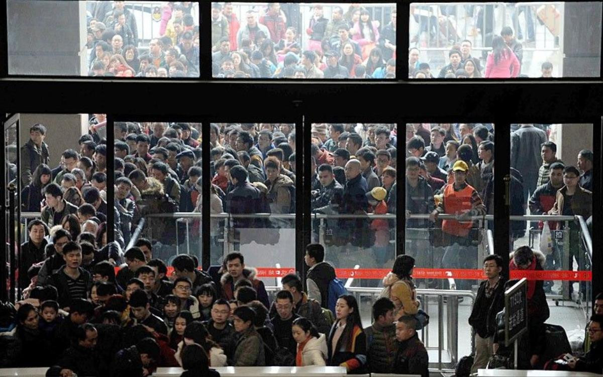 15 Feb 2015, Wuhan, Hubei Province, China --- Crowds of Chinese passengers wait for check-in at the Hankou Railway Station before taking trains to go back home for Spring Festival to celebrate the Chinese Lunar New Year in Wuhan city, central China's Hubei province, 15 February 2015. As hundreds of millions in China flock home to celebrate the Year of the Sheep, the world's biggest human migration places extraordinary pressure on roads and railways, but technology is offering new ways to find a route home. Chinese tradition requires people to gather at their family home before the Lunar New Year begins, on February 19 this year, with authorities expecting more than 2.8 billion trips to be taken over the festive period. Rail is one of the favoured ways to travel and while historically there have been endless queues at the ticket windows, China's official train booking website 12306.cn is helping to relieve co --- Image by © Imaginechina/Corbis