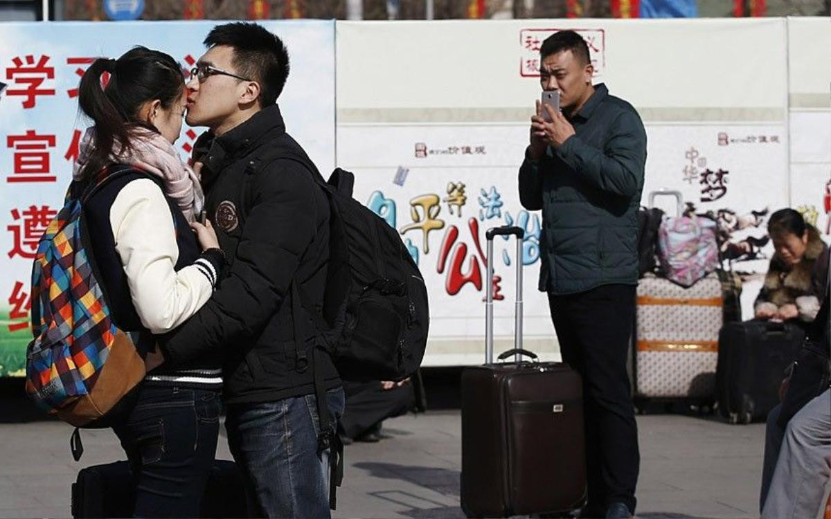 A couple kisses at a railway station in Beijing February 16, 2015. Chinese Ministry of Transport said a total of 2.807 billion trips are expected to be made during the 40-day Spring Festival travel rush, which started on February 4 and will last until March 16, Xinhua News Agency reported. REUTERS/Kim Kyung-Hoon (CHINA - Tags: TRANSPORT SOCIETY)